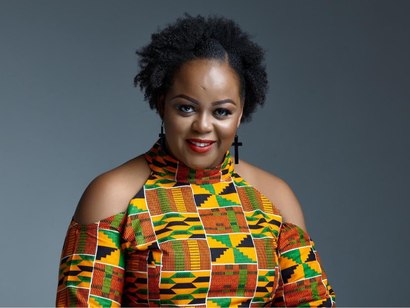 Woman with afro wearing colourful blouse