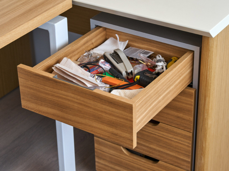 Wooden storage cabinet in an office with many items inside