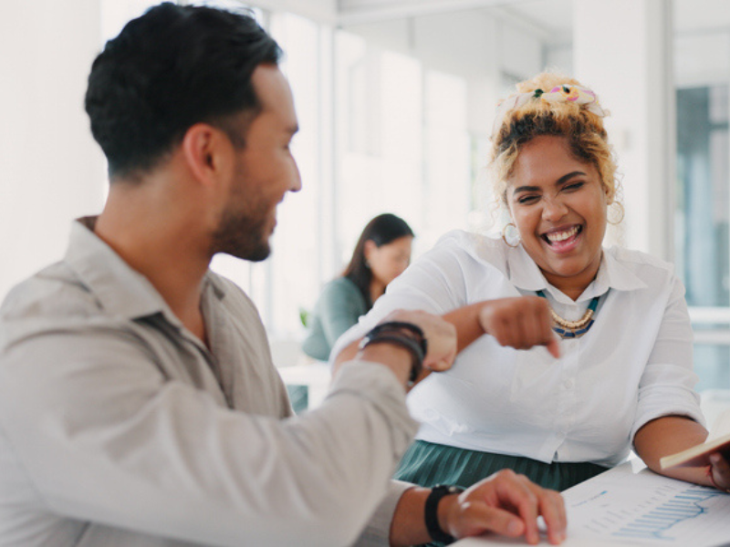 Work colleagues fist bump in celebration as a greeting