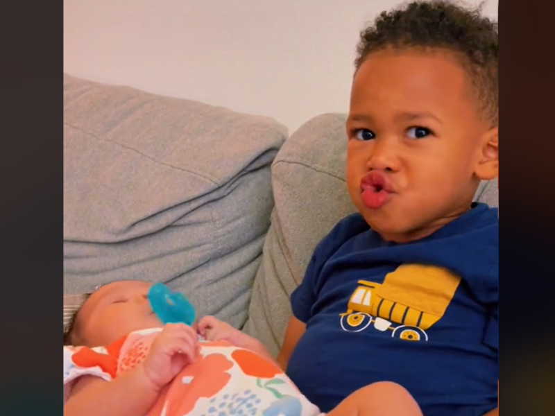 Young boy sitting with his baby sister on his lap