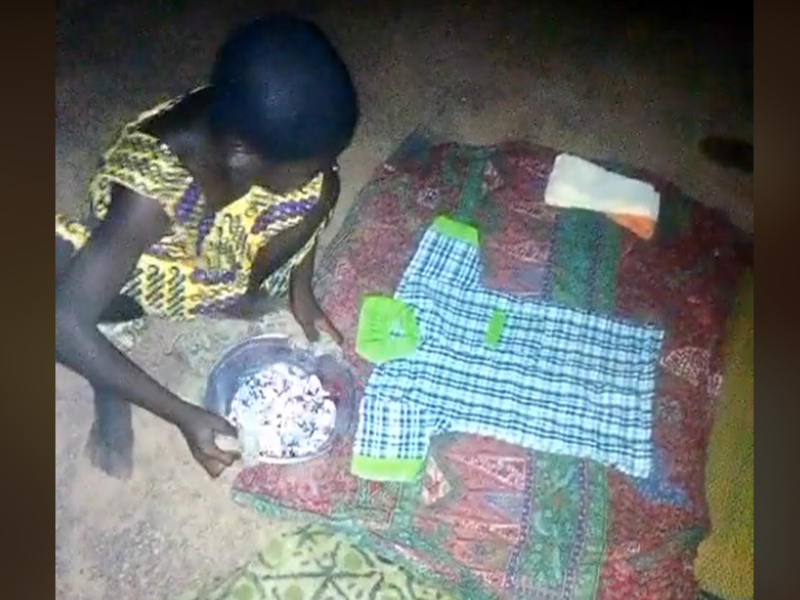 Young girl ironing her school uniform on the ground