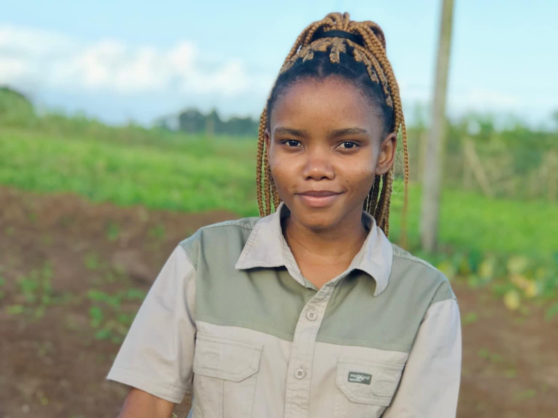 Young woman with braids standing on a farm