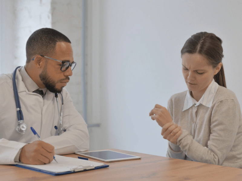 Doctor wearing stethoscope writing medical report