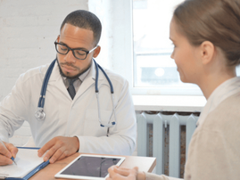 Doctor writes medical report while chatting to patient