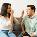 Woman blocks her nose and avoids her boyfriends bad breath