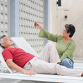 couple relaxing on poolside lounge chairs