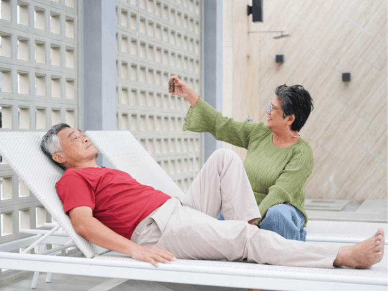 couple relaxing on poolside lounge chairs