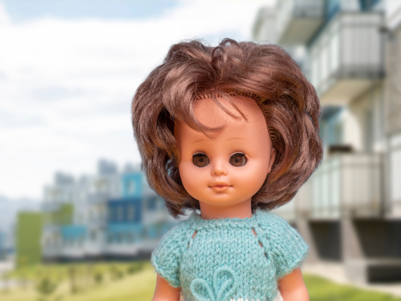 female doll wearing a blue knitted top