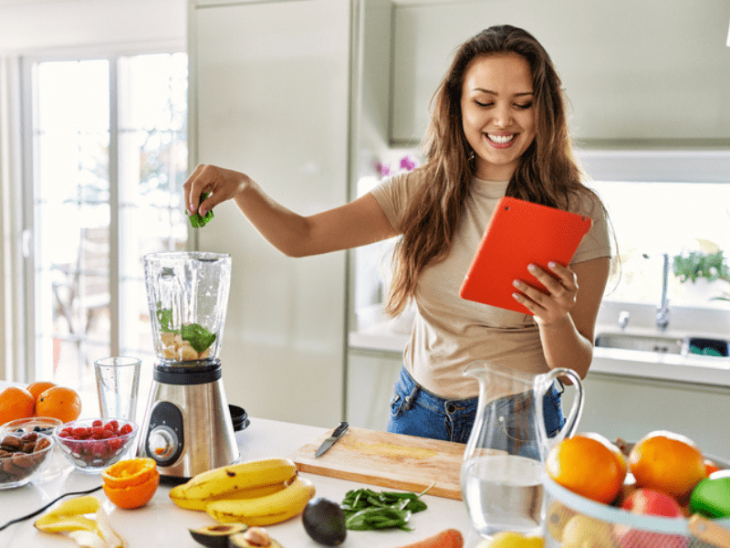 woman preparing a smoothie in a kitchen