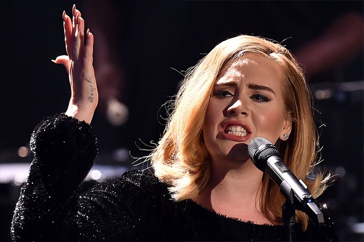 Adele raises her hand like a diva