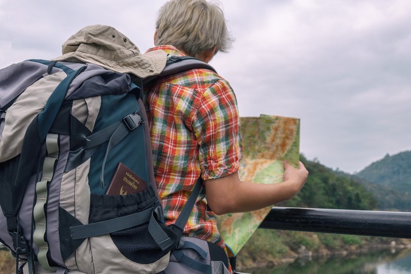 man with backpack reading a map