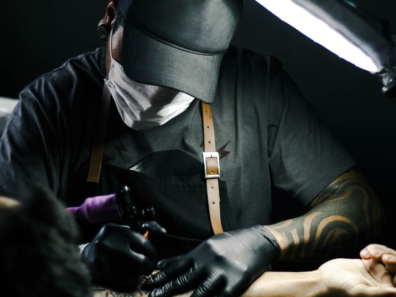 man tattooing arm/pexels