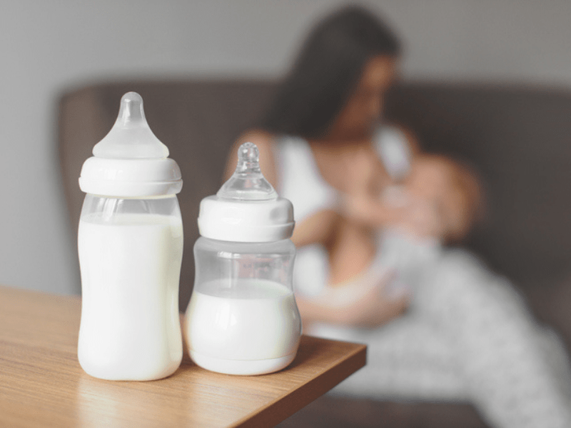 Two bottles of breastmilk on a wooden table