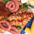 braai meat onions and mielies on a brown cutting board