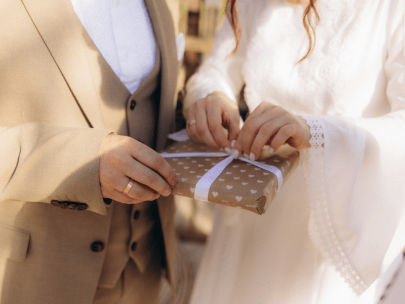 bride and groom opening a wedding gift.png
