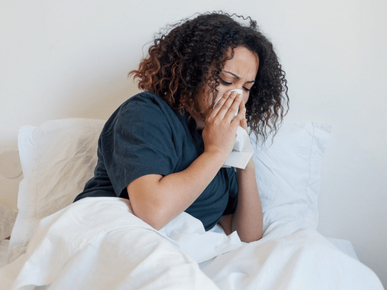 Woman cold flu sick in bed