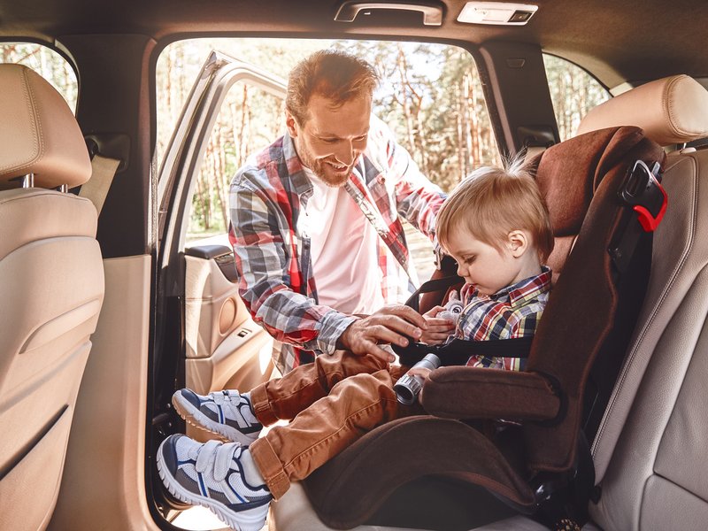 Father putting child in car seat