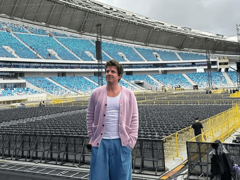 Charlie Puth standing on a stadium stage during soundcheck