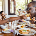 child feeds dad at a restaurant