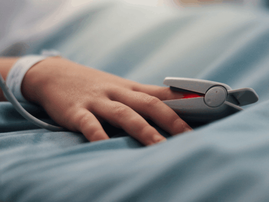 close up of hand with pulse oximeter on a hospital bed