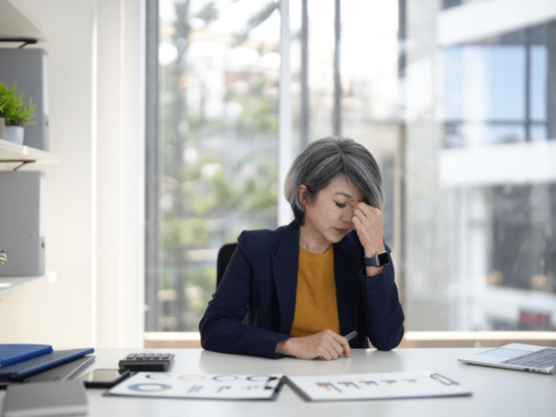Woman looking stressed and overworked in an office