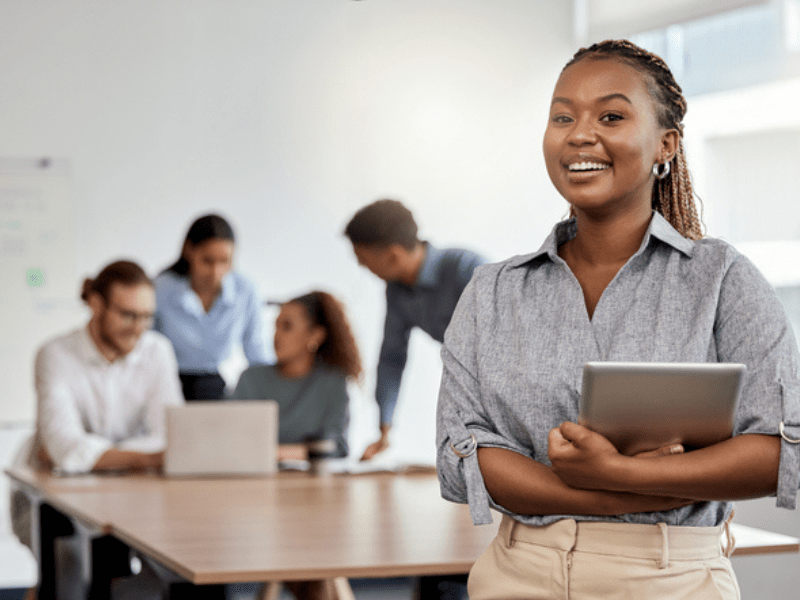 Woman wearing braids poses in boardroom