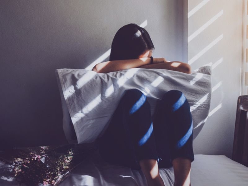 Depressed teenager holding pillow