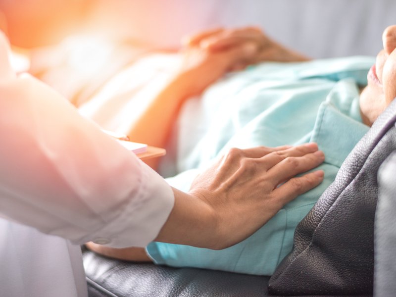 Doctor consulting and comforting elderly patient