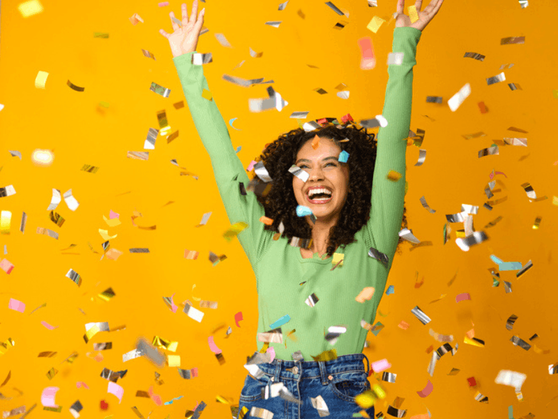 excited woman celebrating is showered in confetti