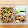 Fried rice and cucumber pieces in a lunch box