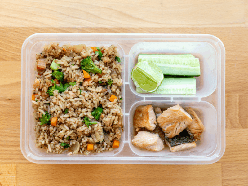 Fried rice and cucumber pieces in a lunch box