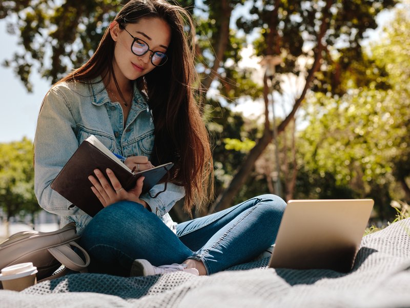 Young woman studying sitting outdoors