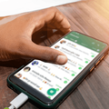 hand scrolls through whatsapp on smartphone