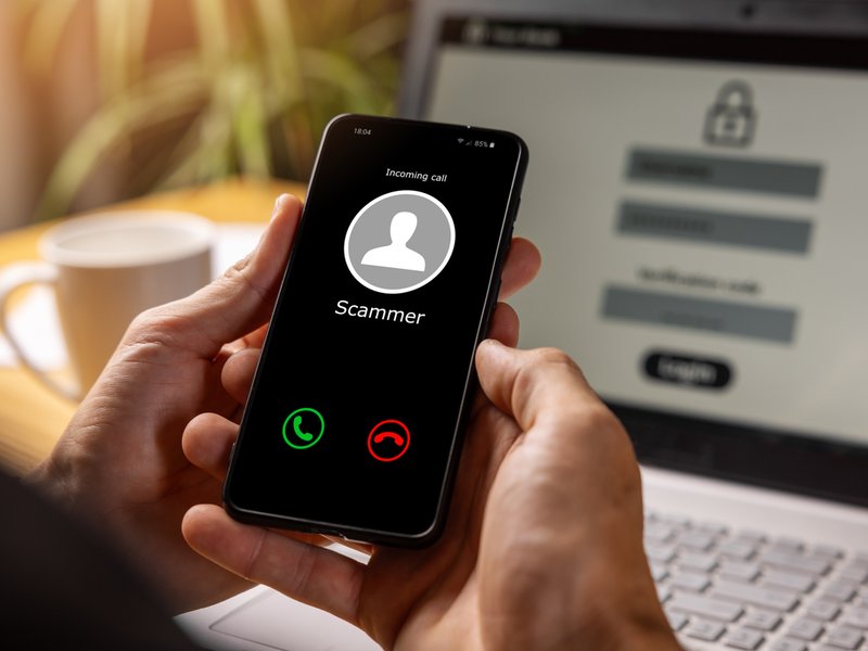 Hands holding phone with incoming call from scammer