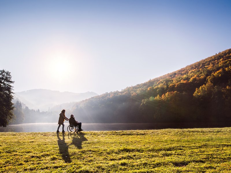 Senior couple with wheelchair in autumn nature. stock photo