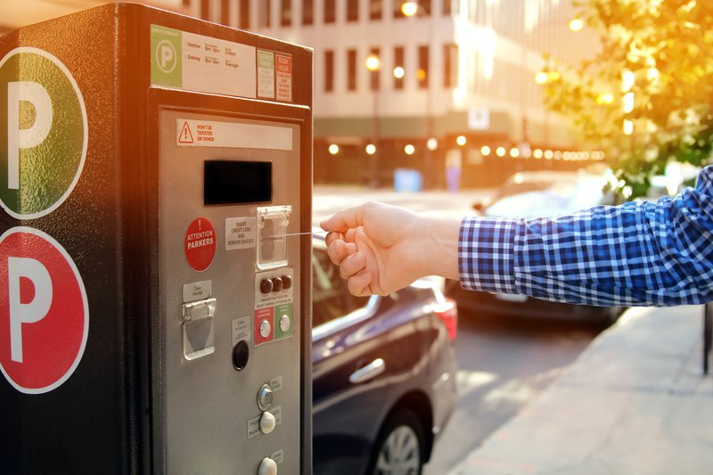 Man is paying his parking using credit card at parking pay station terminal