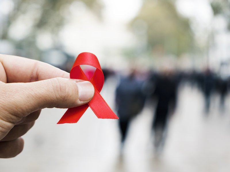 Man with a red ribbon for the fight against AIDS stock photo