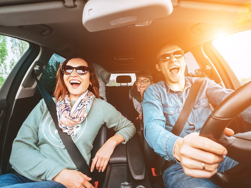 Cheerful young traditional family has a long auto journey and singing aloud the favorite song together. Safety riding car concept wide angle view image. stock photo