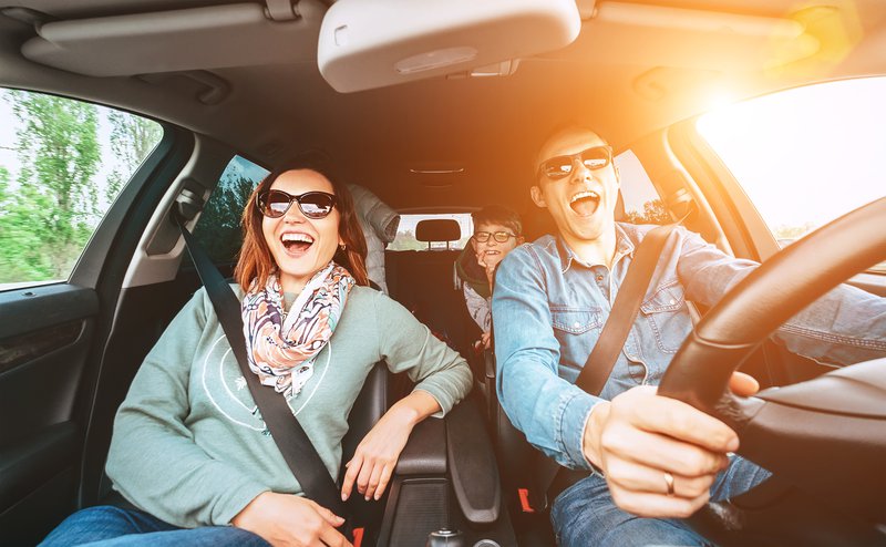 Cheerful young traditional family has a long auto journey and singing aloud the favorite song together. Safety riding car concept wide angle view image. stock photo