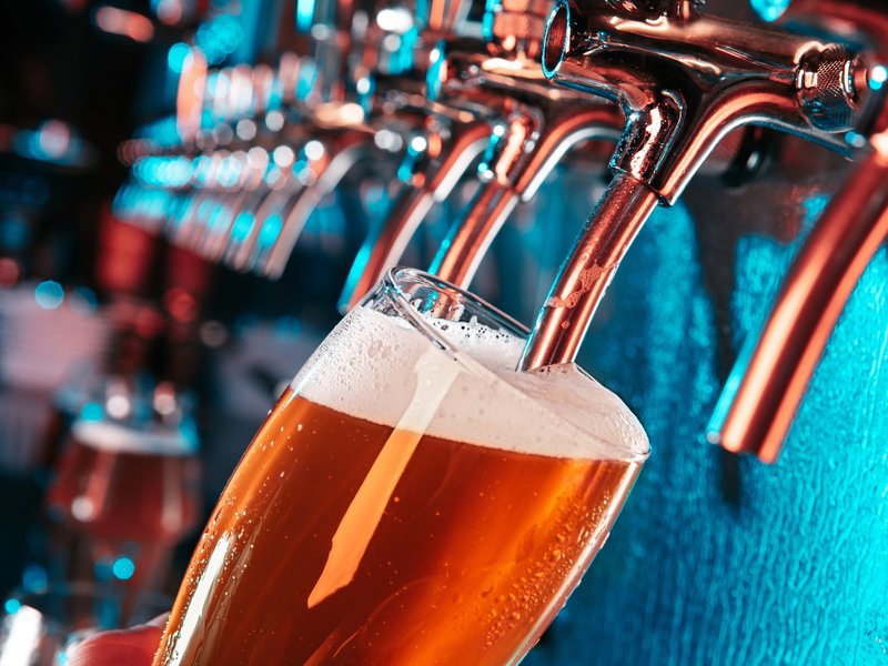 Hand of bartender pouring a large lager beer in tap stock photo