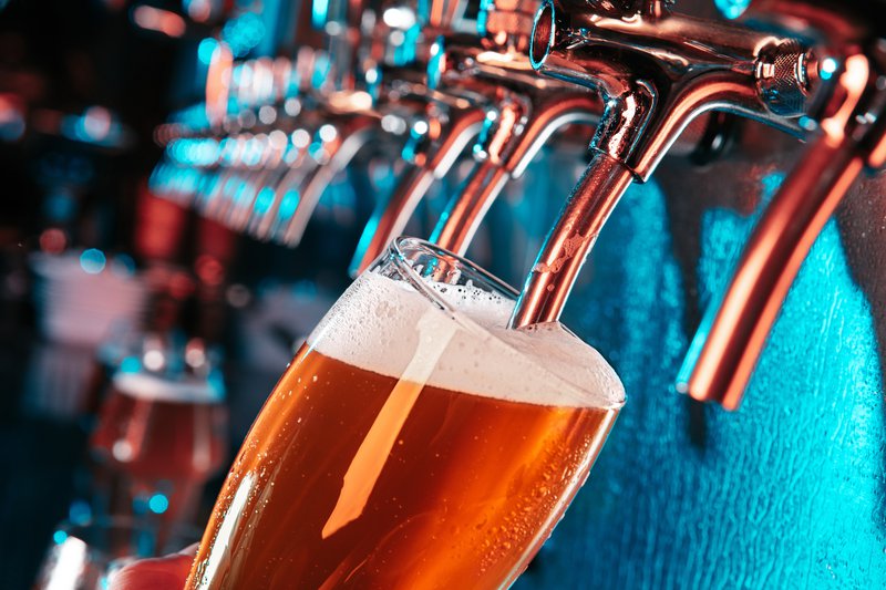 Hand of bartender pouring a large lager beer in tap stock photo