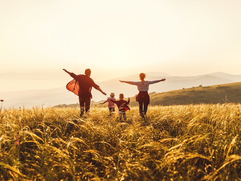 Happy family: mother, father, children son and daughter runing and jumping on sunset stock photo