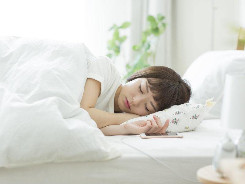 Woman sleeping next to charging phone