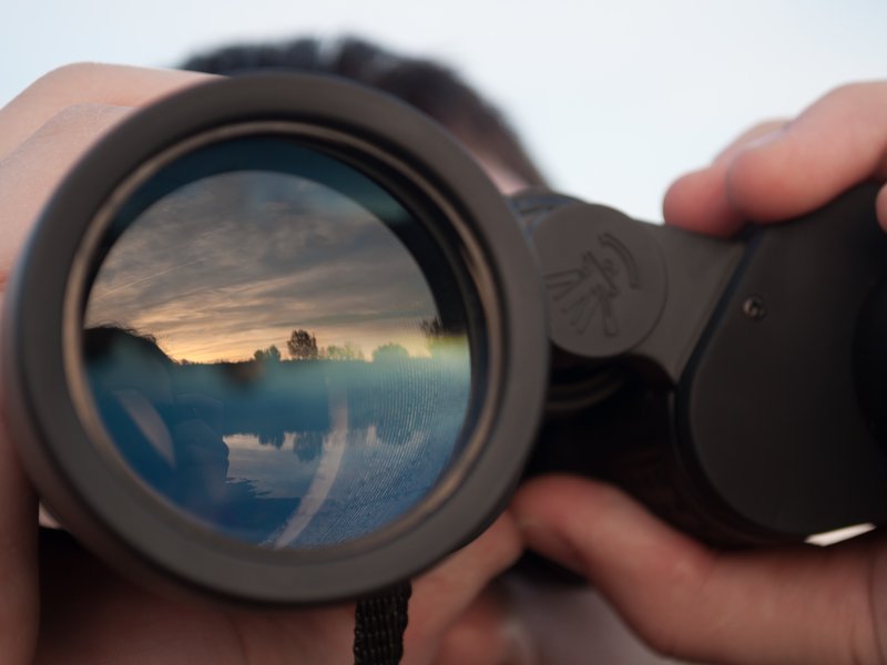 Man looking through binoculars stock photo