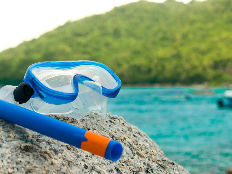 Snorkeling equipment: snorkel and diving google on the stone. stock photo