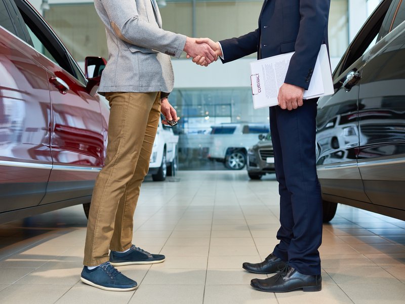 People Shaking Hands in Car Showroom