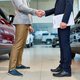 People Shaking Hands in Car Showroom