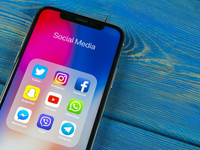 Apple iPhone X on office desk with icons of social media facebook, instagram, twitter, snapchat application on screen. Social network. Starting social media app