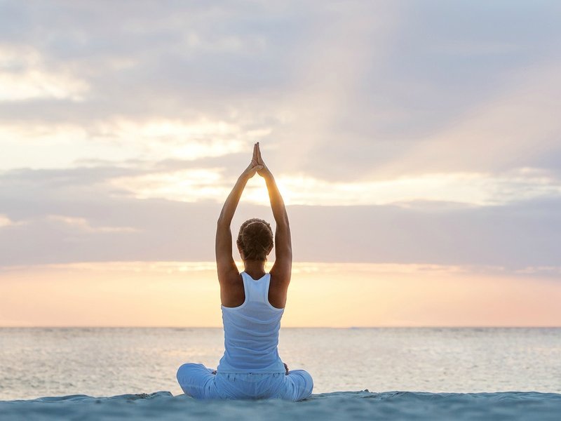 Woman meditating at the beach