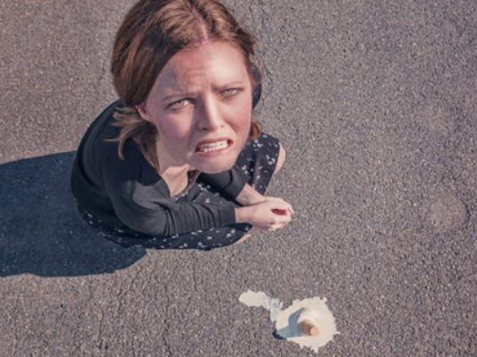 woman sad because she dropped her ice cream